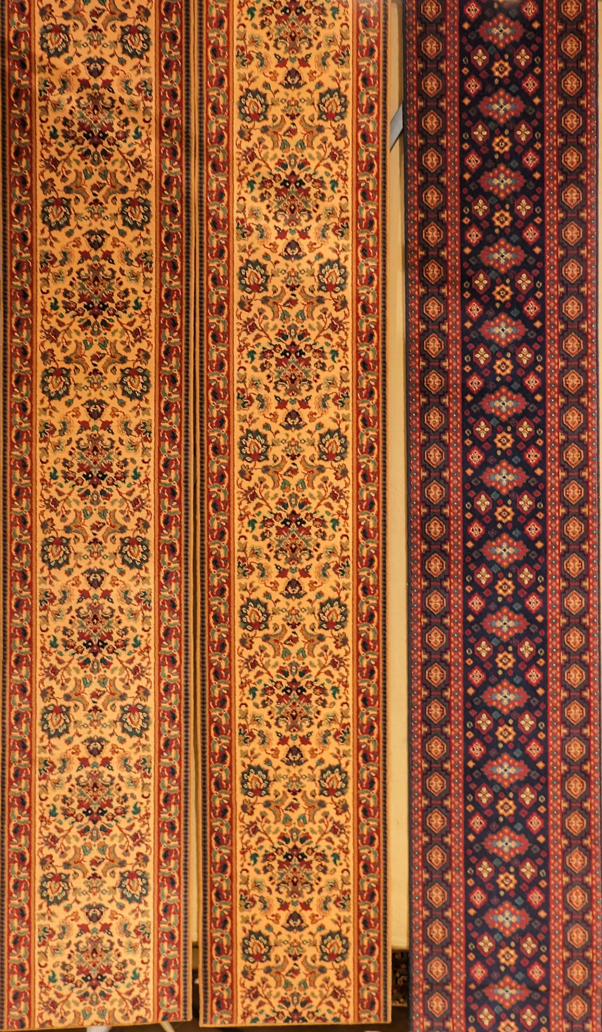Patterned red, gold, and purple woven textile hanging vertically