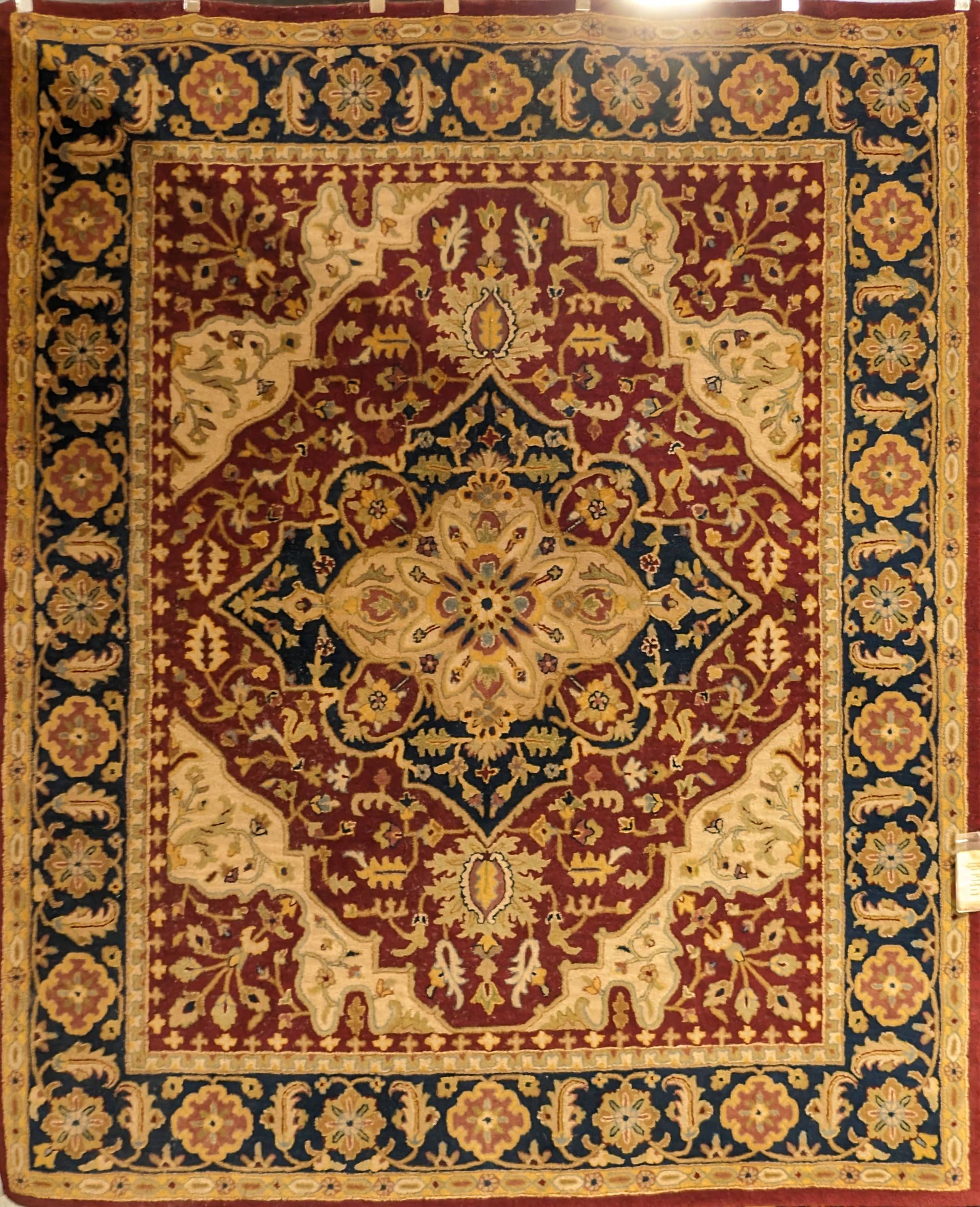 Ornate red and gold Persian rug with a central floral medallion and detailed border pattern