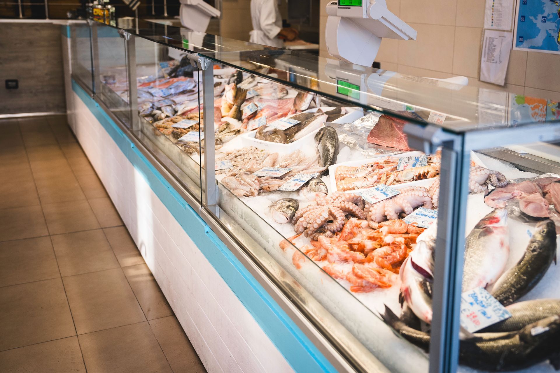 Vetrina espositiva di pesce e frutti di mare assortiti in un banco del mercato.
