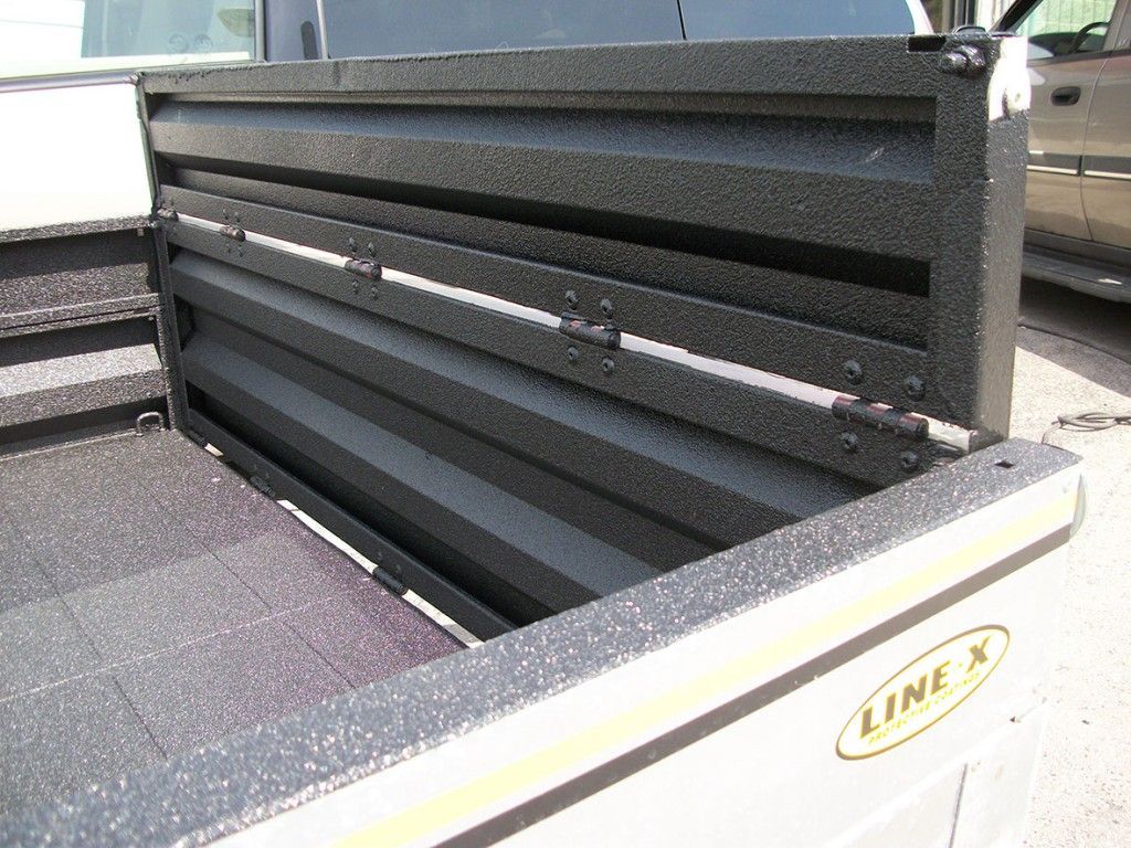 Benne de pick-up avec revêtement Line-X noir et hayon nervuré repliable.