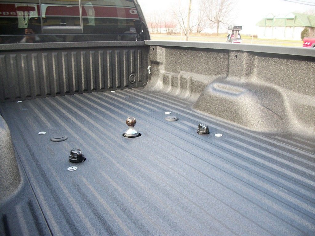 Plateau de pick-up avec attelage col de cygne installé. Revêtement de plateau noir, plusieurs points d'ancrage.