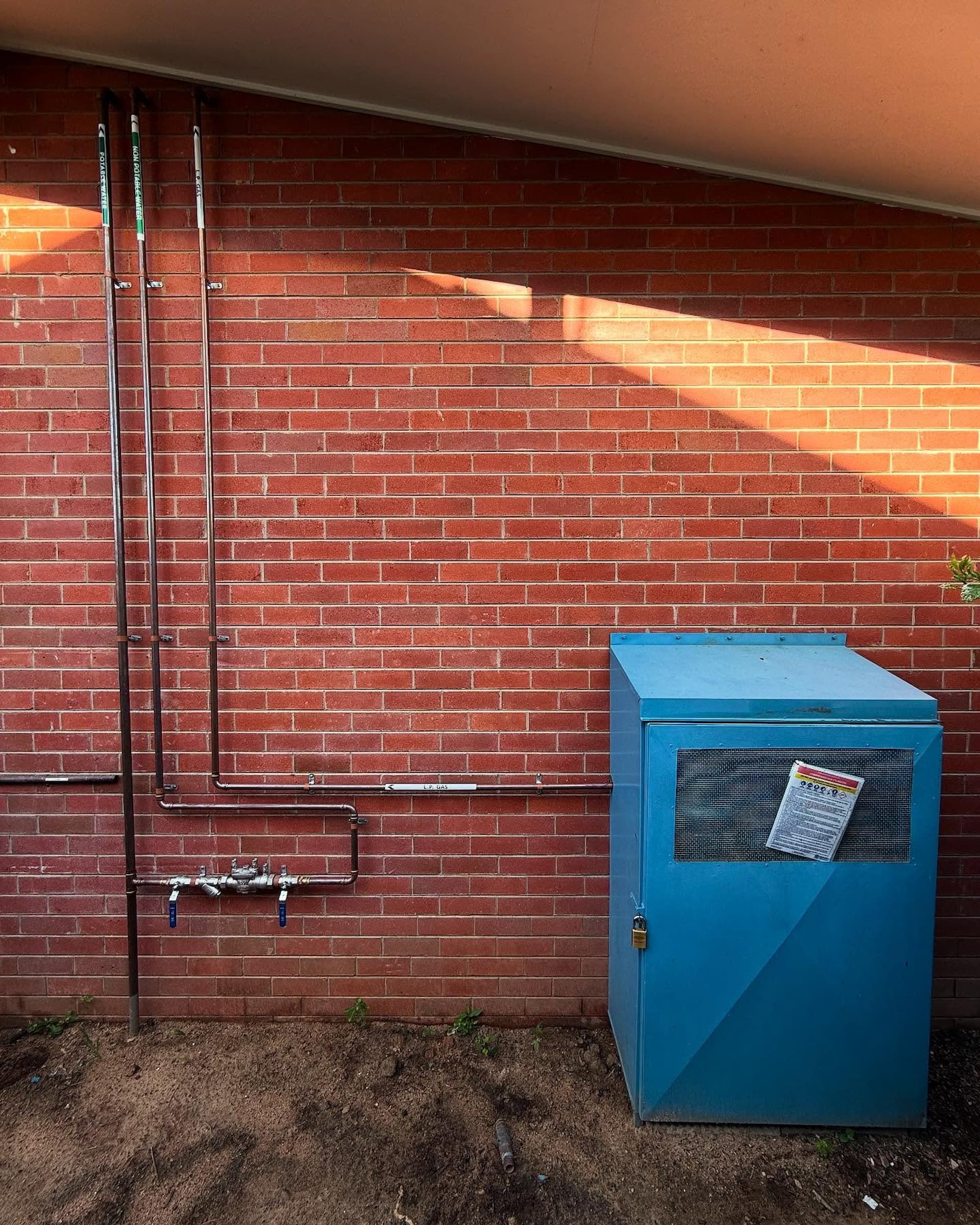 A Man Wearing a Blue Shirt That Says  a & B Plumbing on It — CJM Plumbing & Roofing Mackay in Mackay, QLD