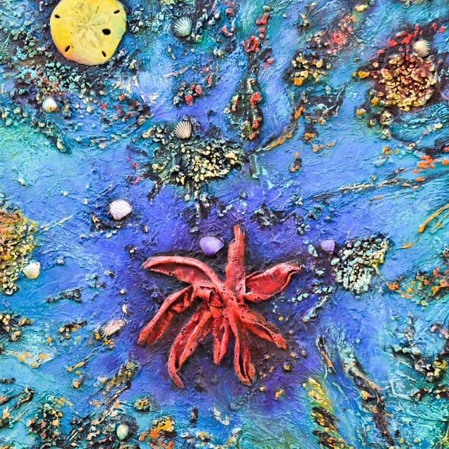 Abstract blue artwork with a red starfish-like form and a yellow moon at the top left.