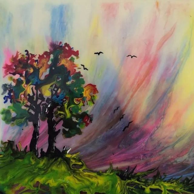 Colorful abstract landscape with trees on a green hill under a pastel sky and flying birds