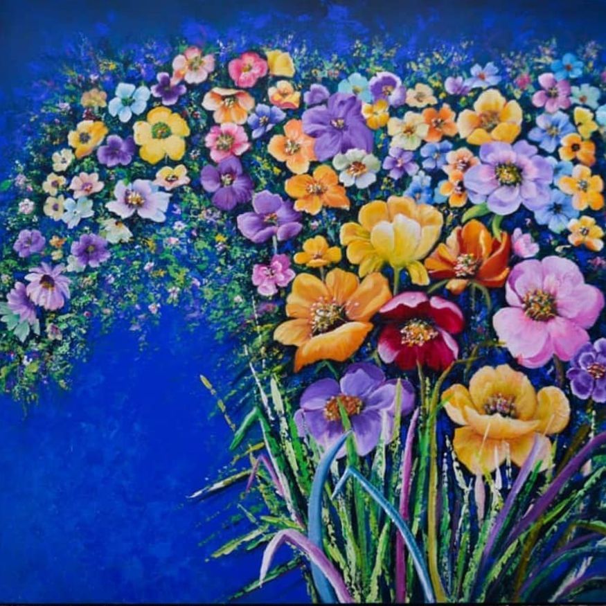 Bright bouquet of colorful flowers against a vivid blue background, with purple, yellow, pink, and red blooms.