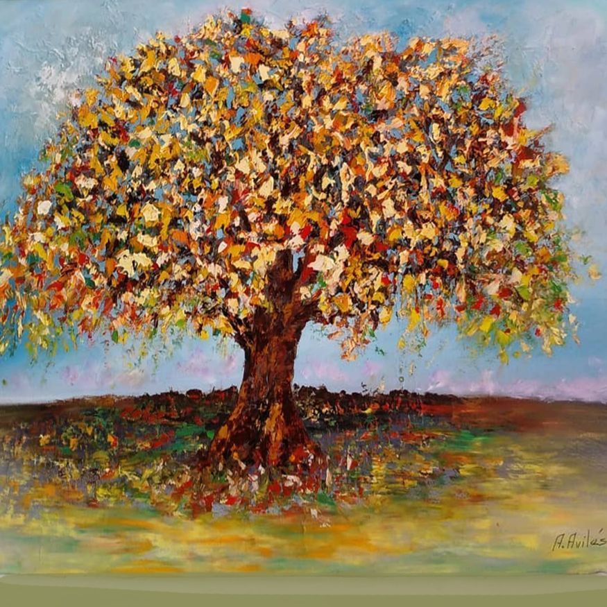 Colorful painted tree with a thick trunk in a grassy landscape under a pale sky