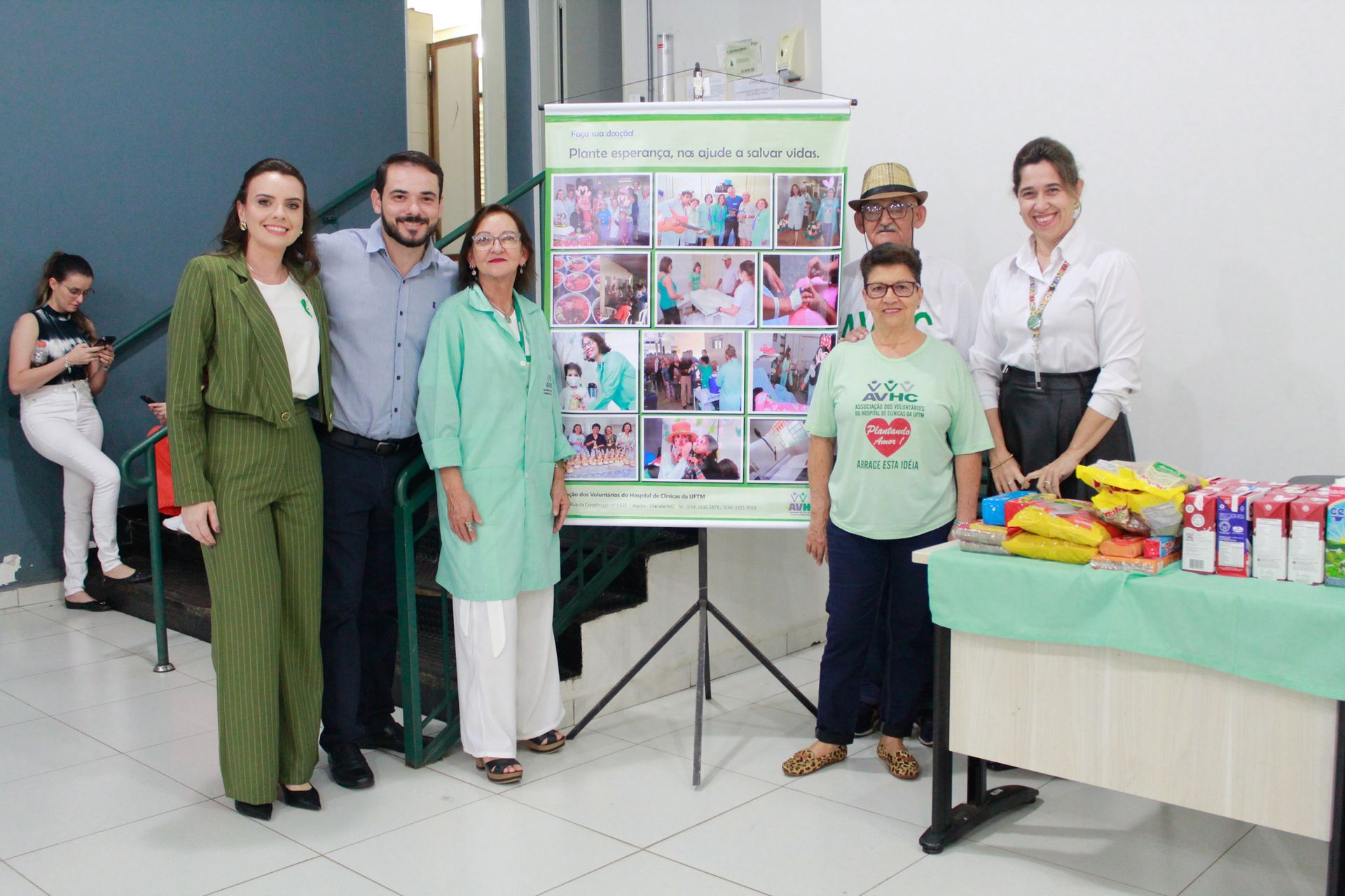 Um grupo de pessoas está posando para uma foto em frente a uma mesa.
