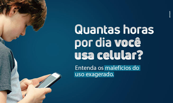 Um menino está olhando para um celular.