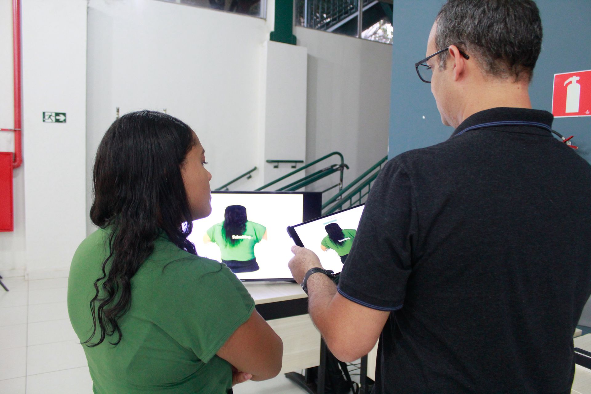 Um homem e uma mulher estão olhando para uma tela de computador