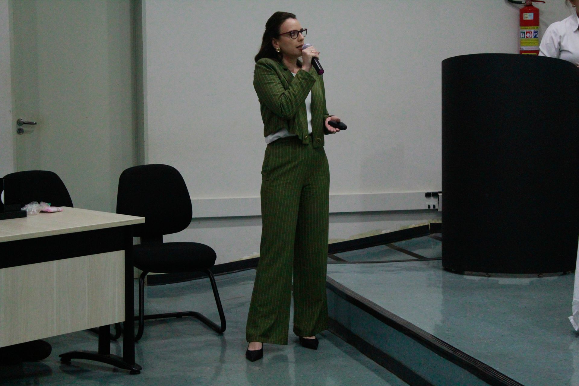 Uma mulher de terno verde está falando em um microfone