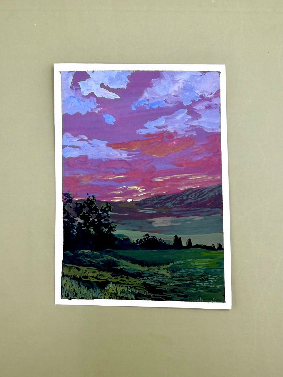 Colorful sunset landscape painting with purple clouds over a green field and silhouetted trees