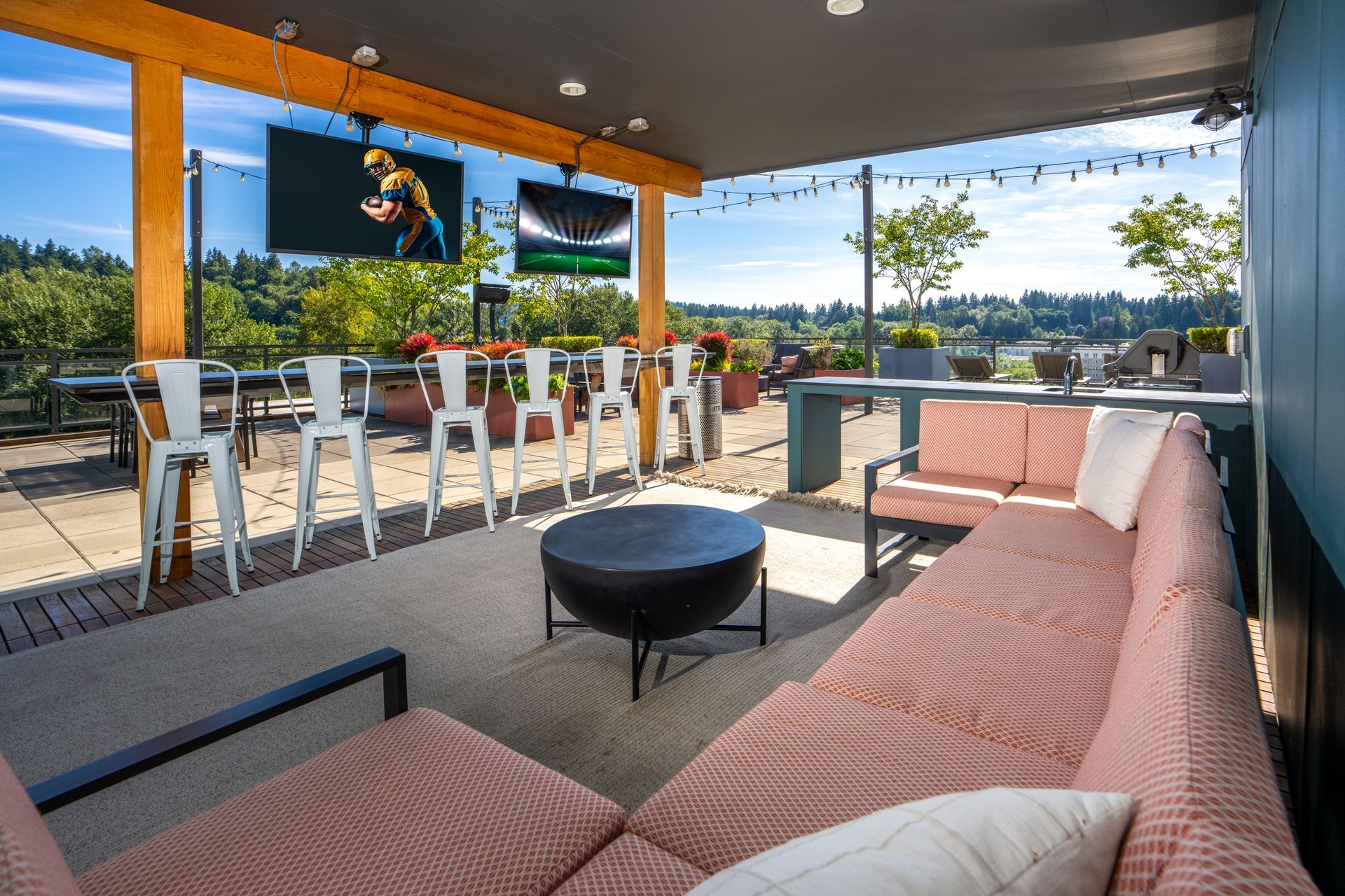 A patio with a couch , table , chairs and a television.