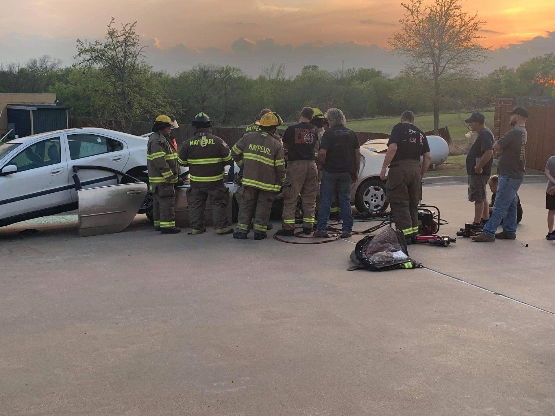 A group of firefighters are training on extrication on a damaged car.