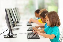 A group of children are using computers in a computer lab.