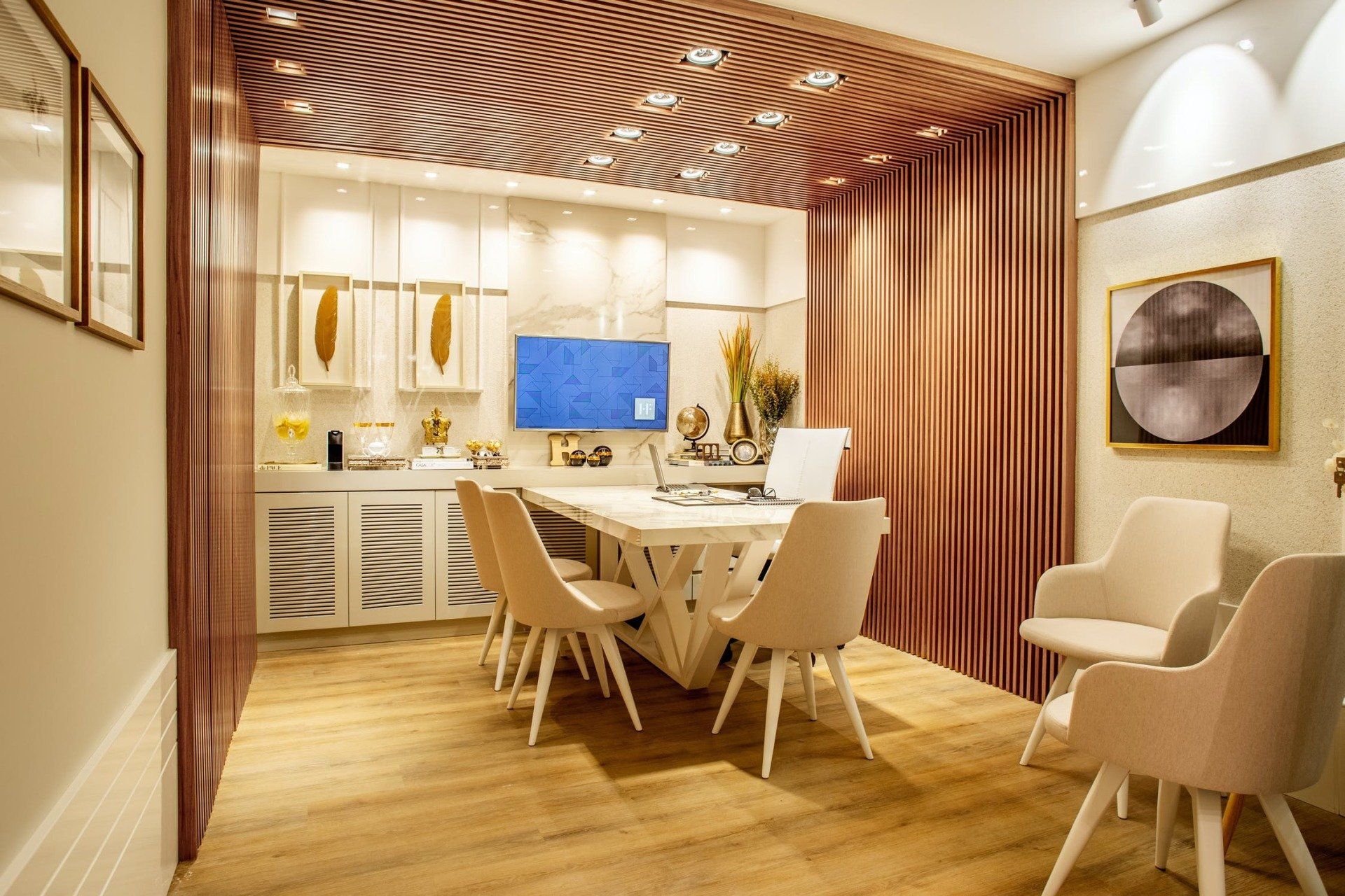 A modern office space with a meeting table, chairs, art, and curtains in warm colors.