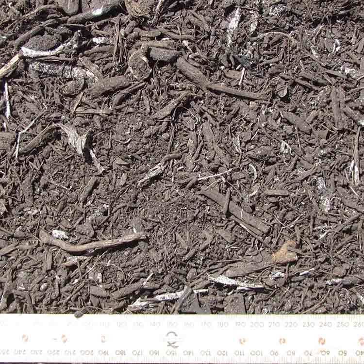 Dark Brown Mulch With Wood Chips and a White Ruler — Kuranda Landscape Supplies in Kuranda, QLD