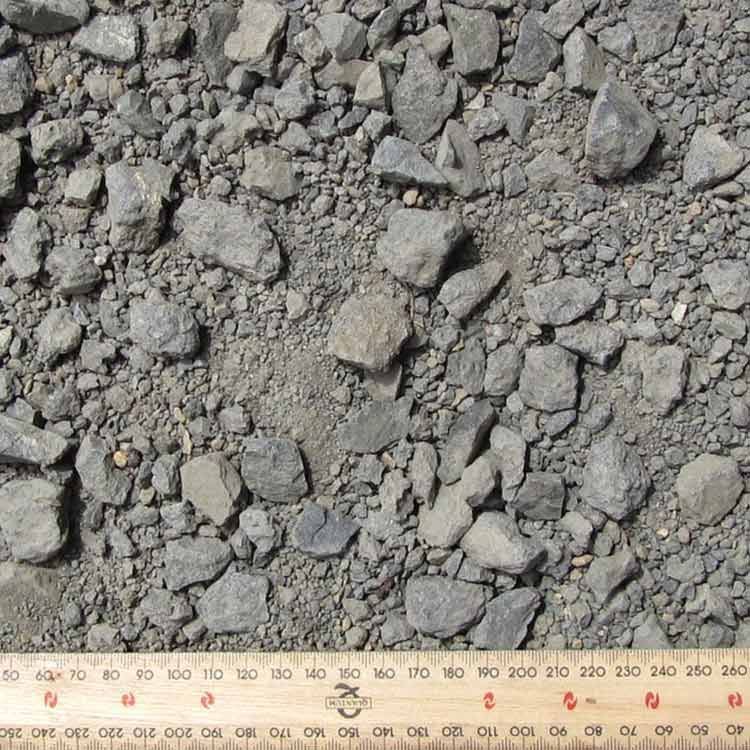 Close-up of a Pile of Gray Crushed Rock Aggregate With a Wooden Ruler for Scale — Kuranda Landscape Supplies in Kuranda, QLD