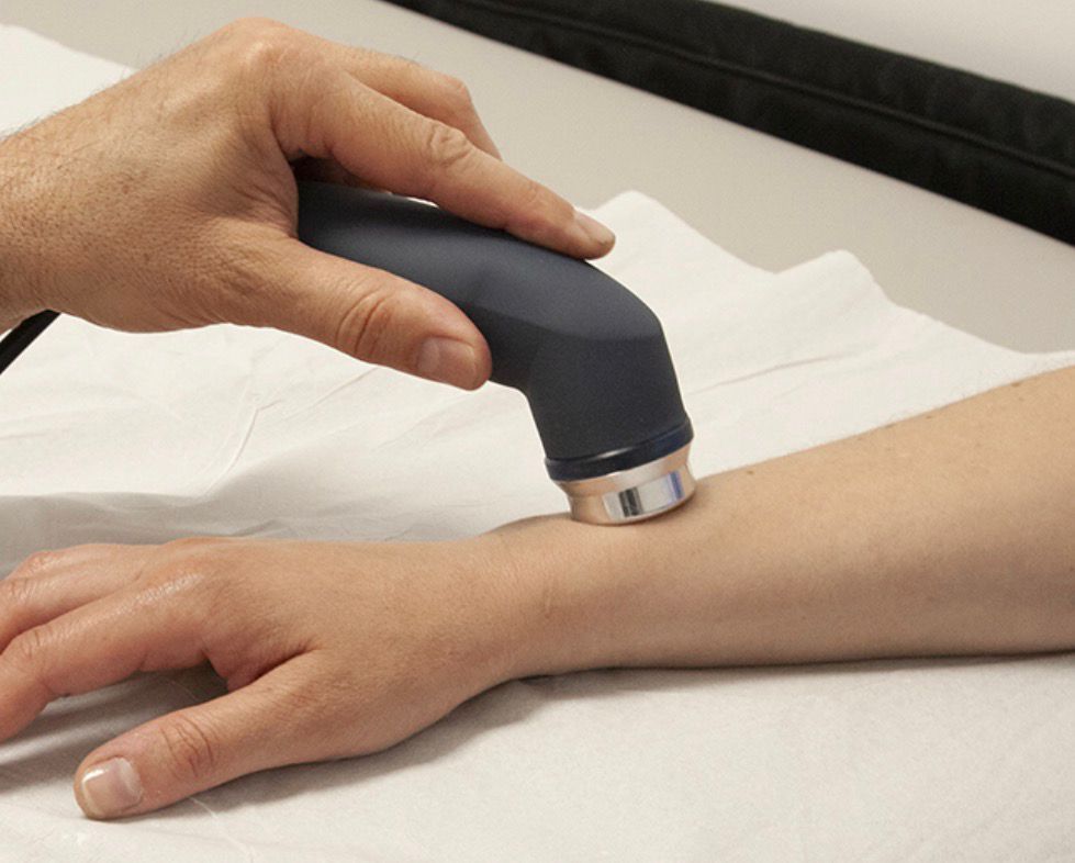 Un medico utilizza una sonda a ultrasuoni sulla gamba di un paziente durante una seduta di fisioterapia.