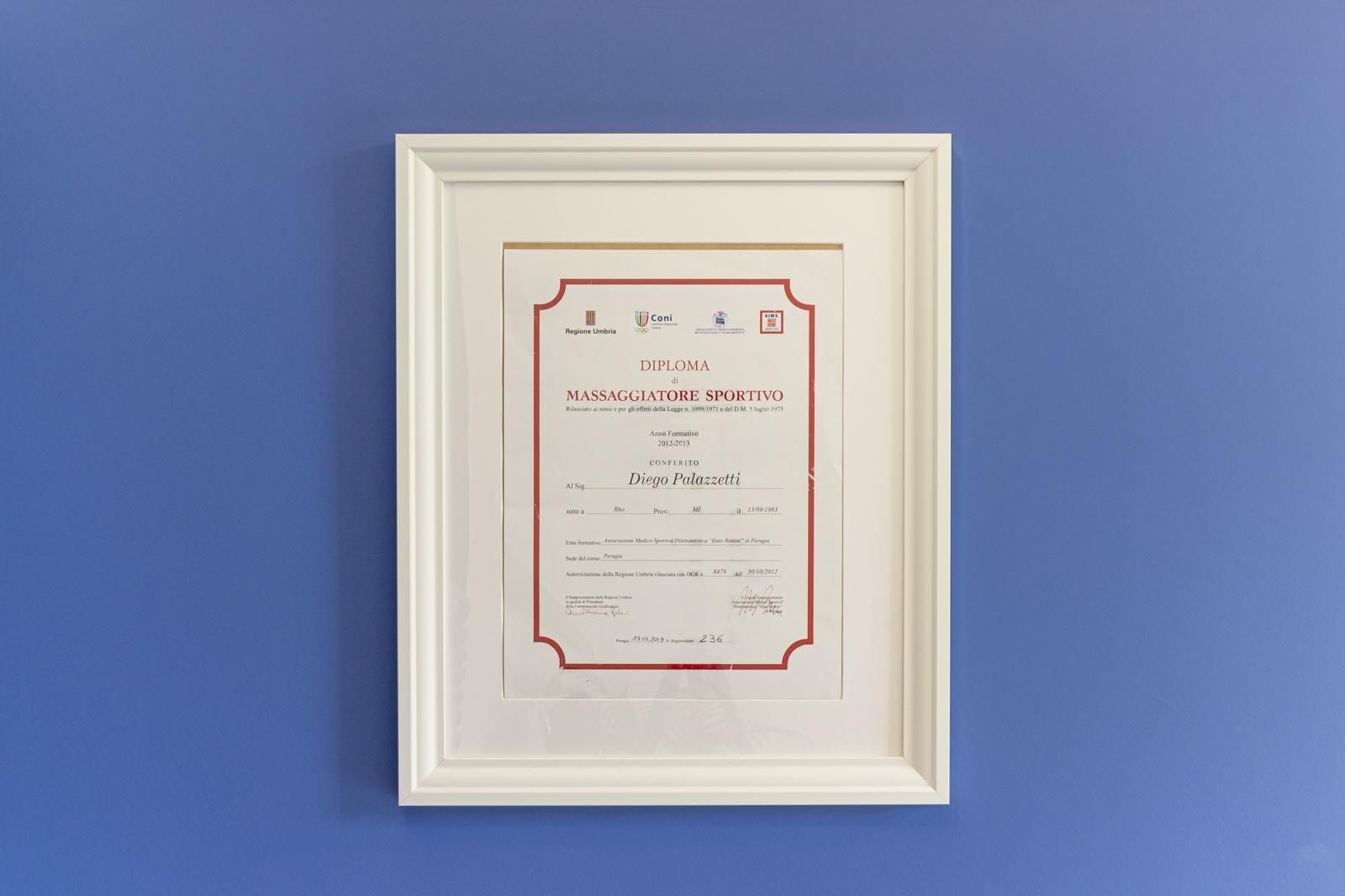 Certificato incorniciato con bordo rosso su una parete blu