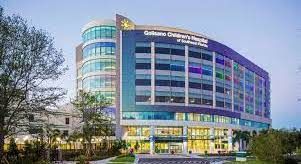 Modern curved glass office building with colorful illuminated windows at dusk