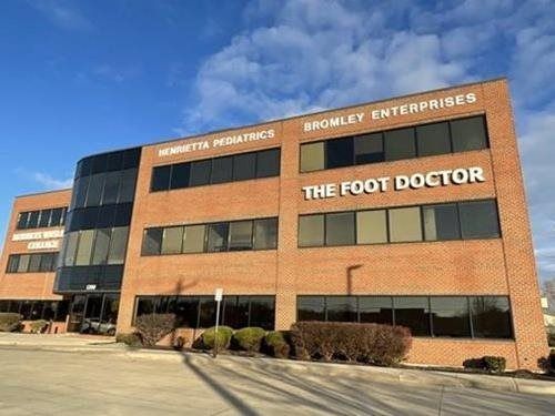 Brick office building with signs for The Foot Doctor and Bromley Enterprises under a blue sky