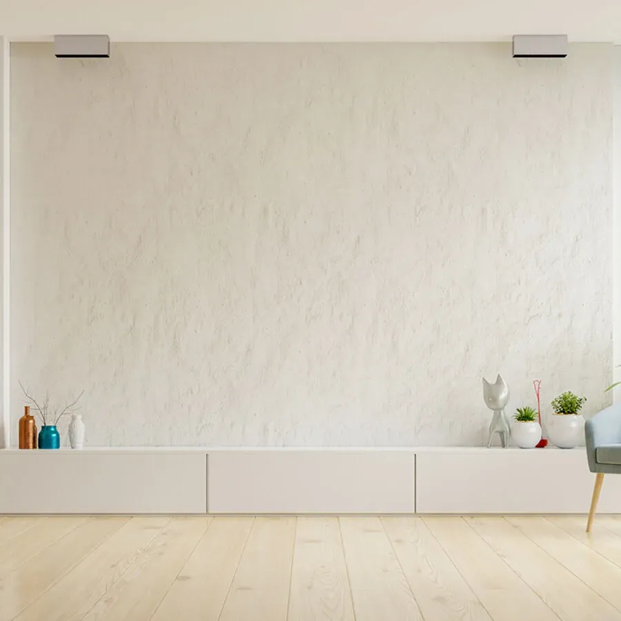 An empty living room with a white wall and a wooden floor.