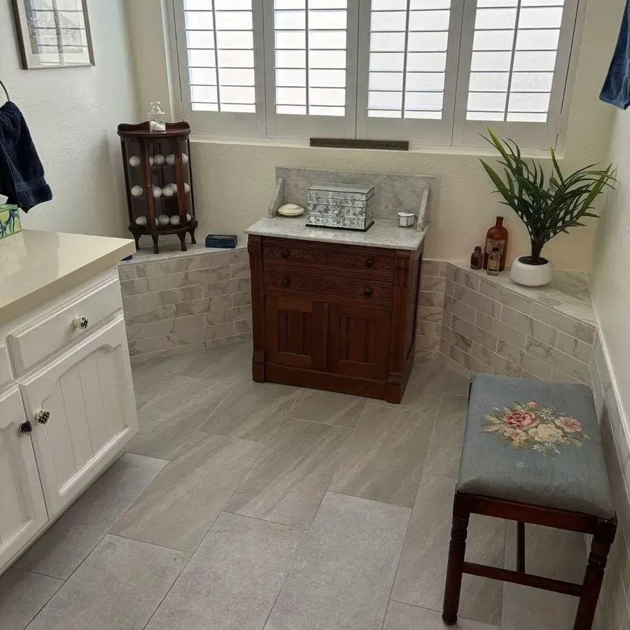 A bathroom with a wooden vanity and a stool