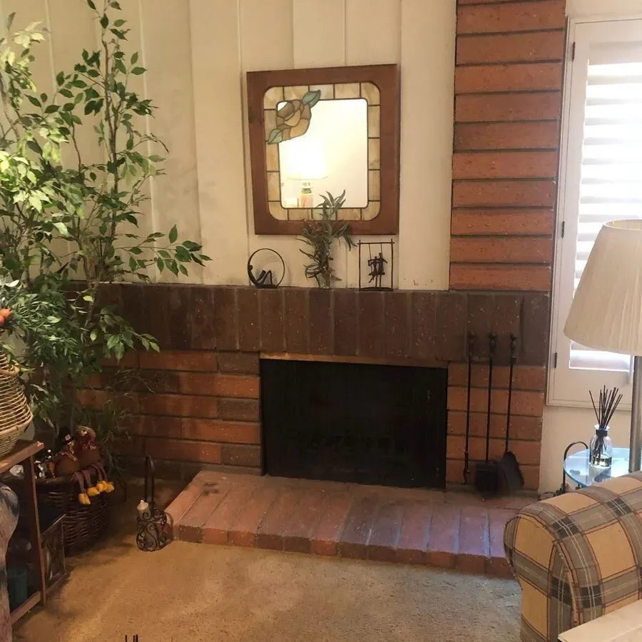 A living room with a fireplace and a mirror