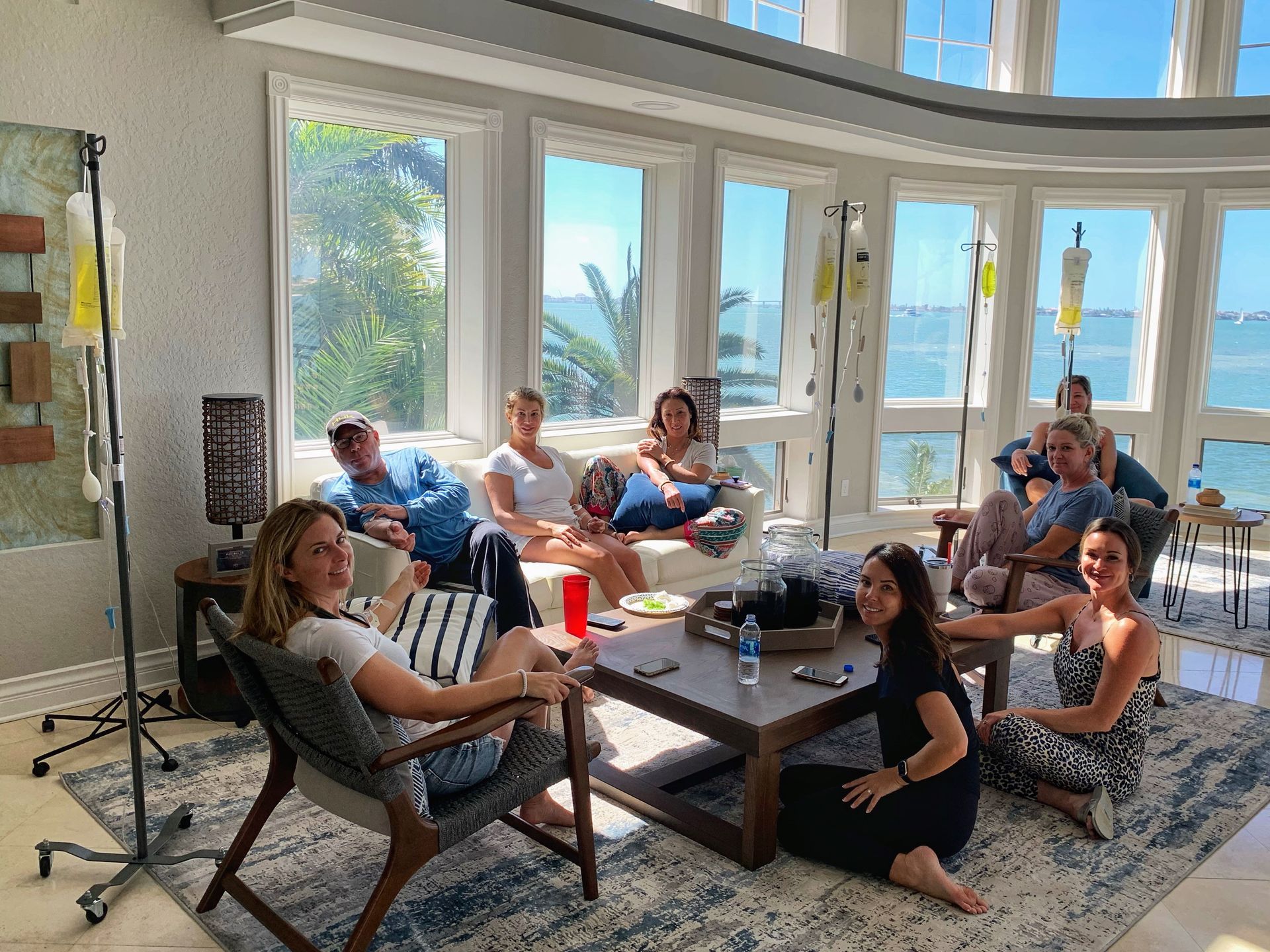 A group of people are sitting around a coffee table in a living room.