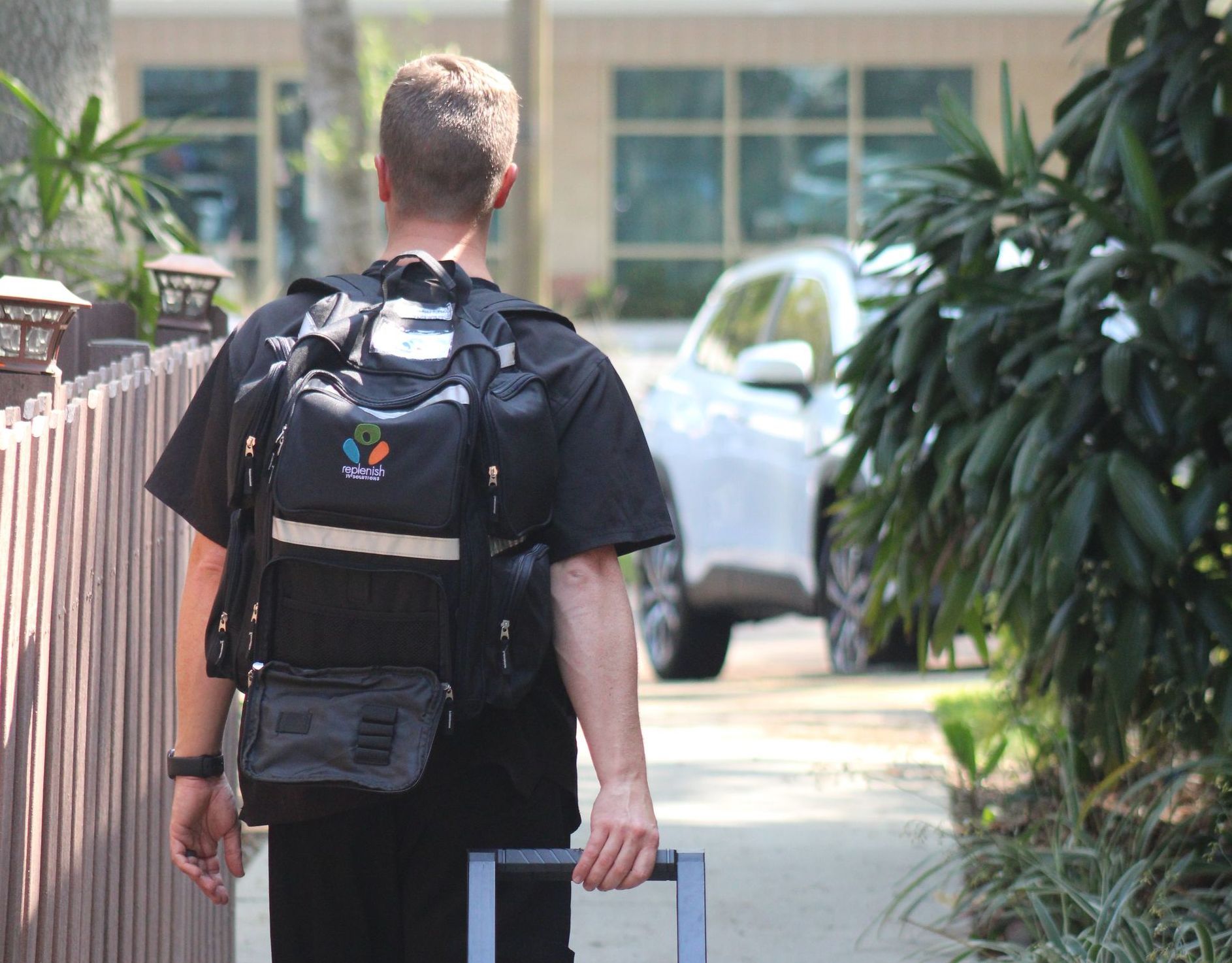 a man with a backpack and a suitcase is walking down a sidewalk .