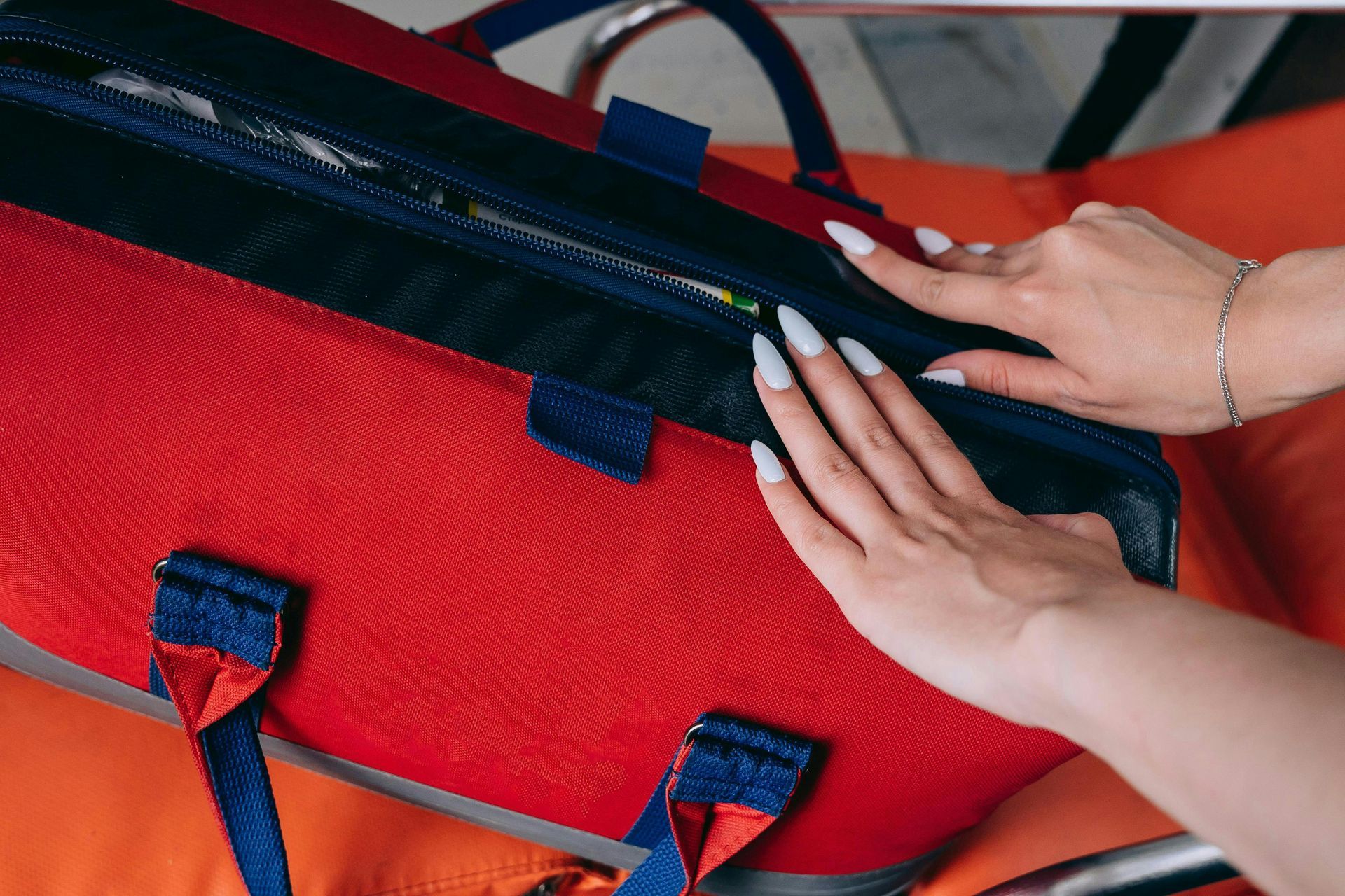 A woman is putting something in a red bag.