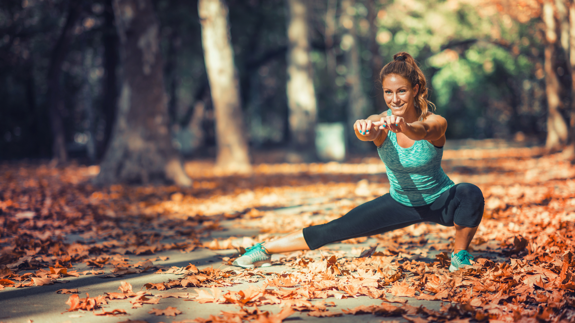 woman stretching in a park during the autumn season