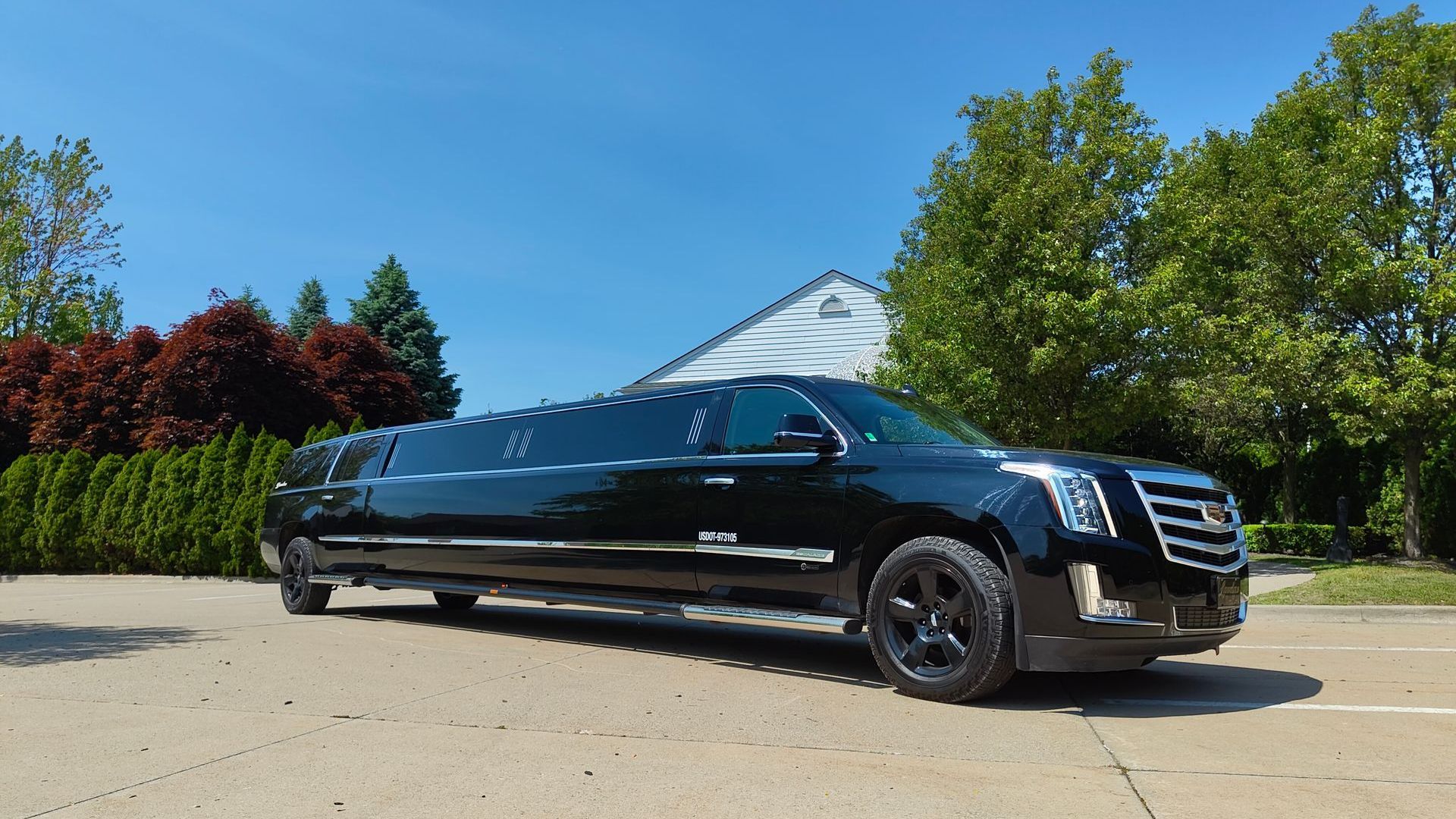 A black limousine is parked in front of a building.