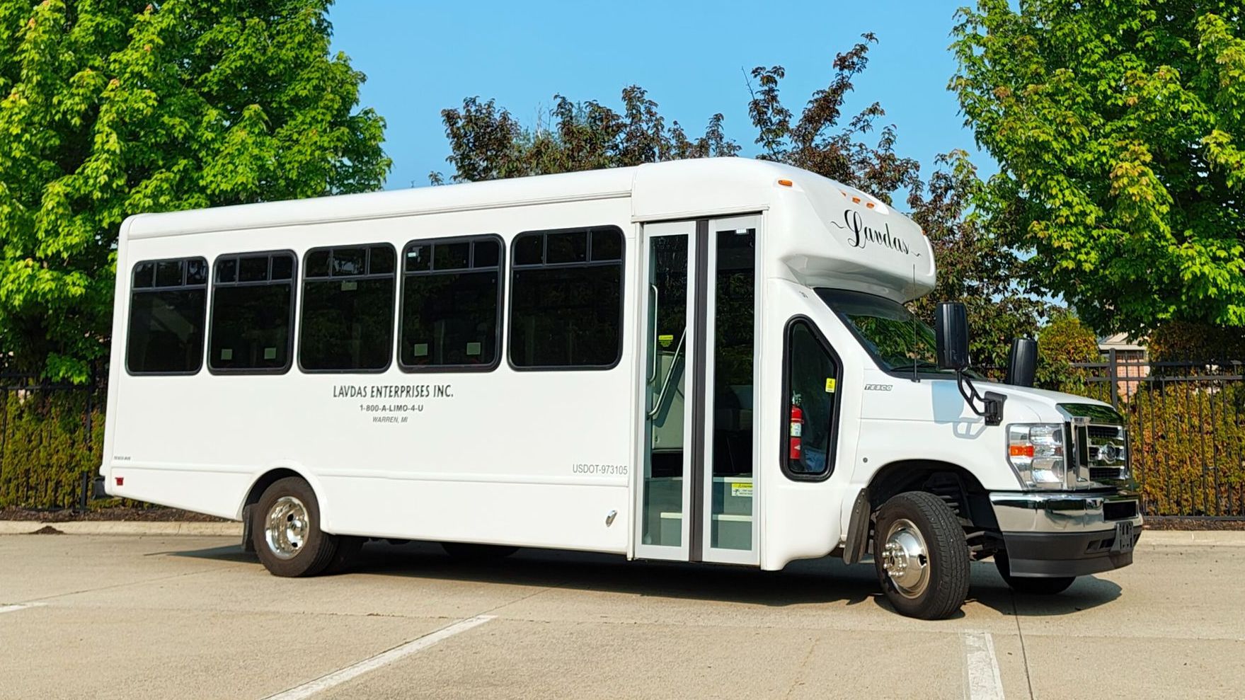 A row of buses are parked in a parking lot