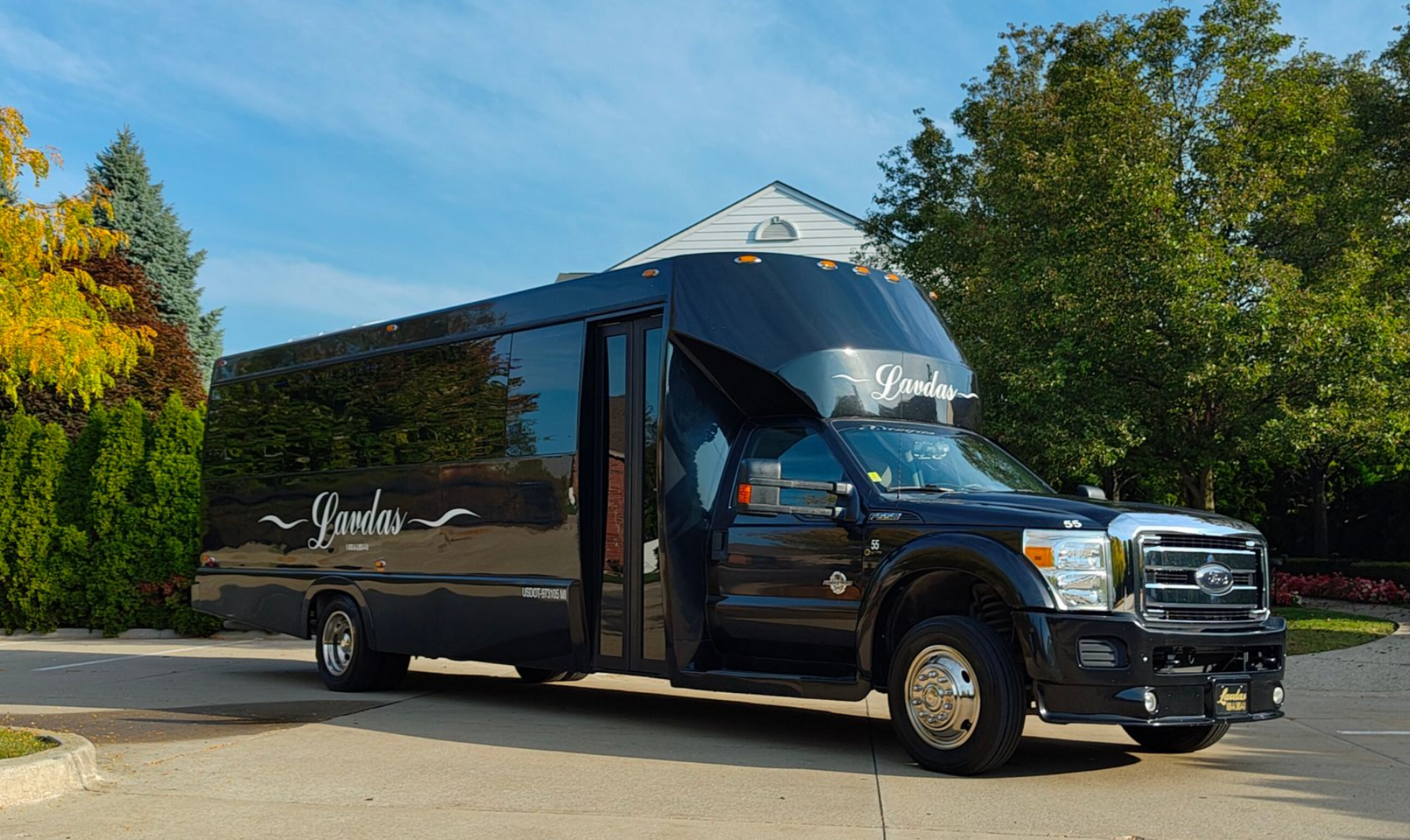 A black shuttle bus is parked on the side of the road.