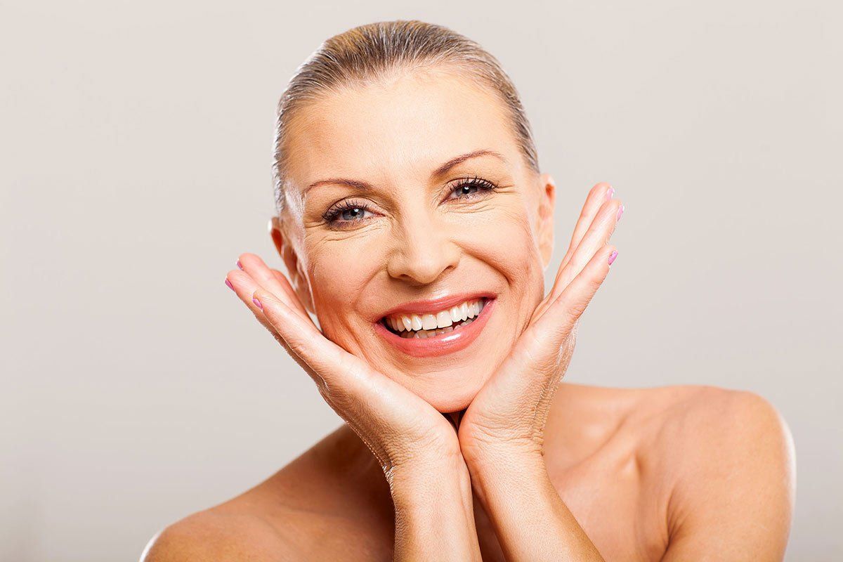 woman smiling with hands on chin