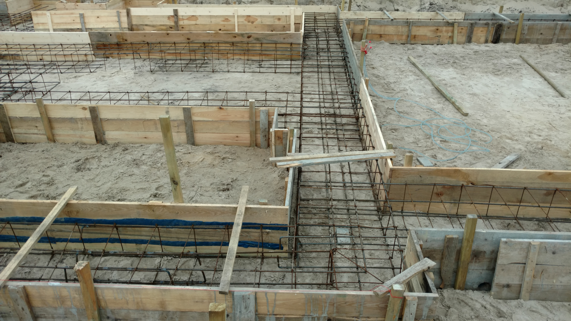 Home foundation repair crew stabilizing cracked structural wall