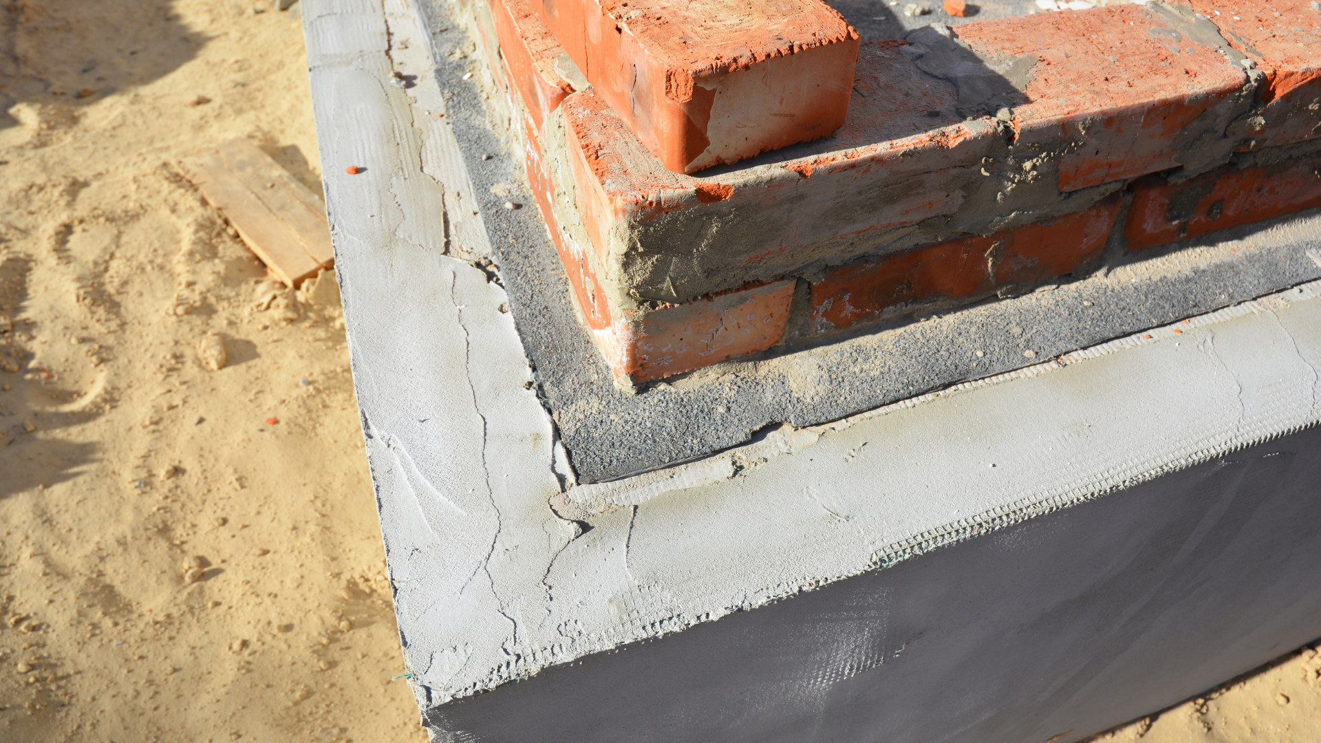 Basement wall repair crew sealing moisture damage and structural cracks