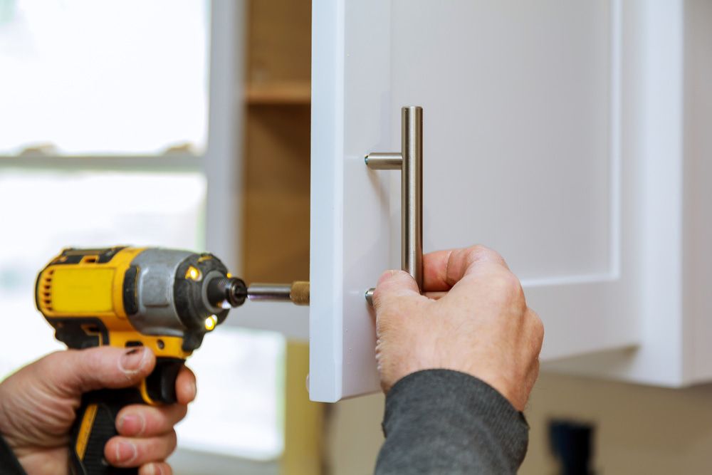 Person is Installing a Cabinet Handle With a Drill — Ken Willis Joinery Pty Ltd In South Grafton, NSW