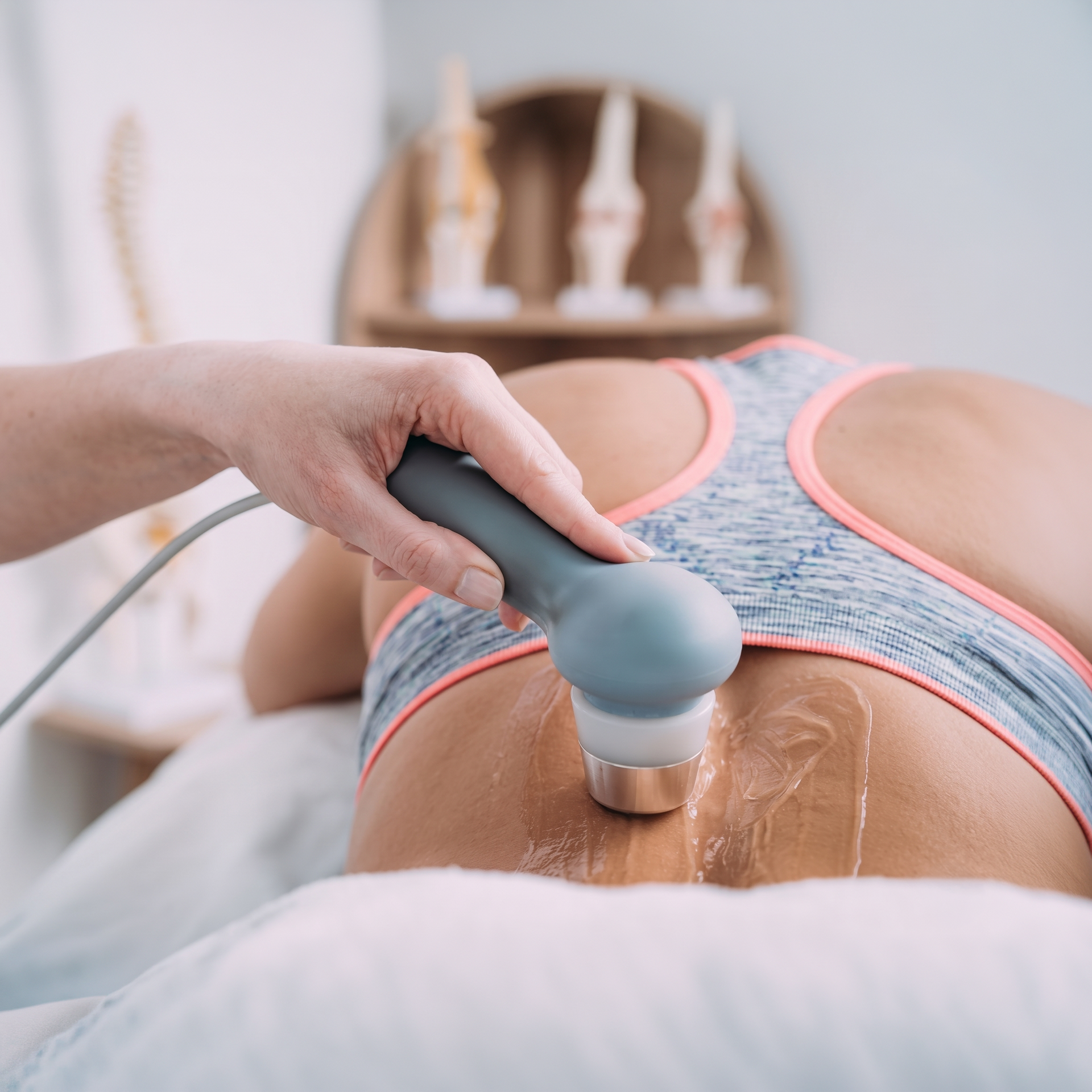 Handheld device treating lower back with gel in a clinical setting