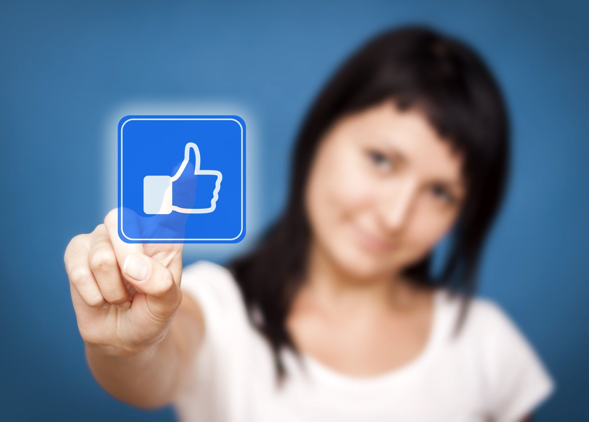 A woman is pressing a button with a thumbs up on it