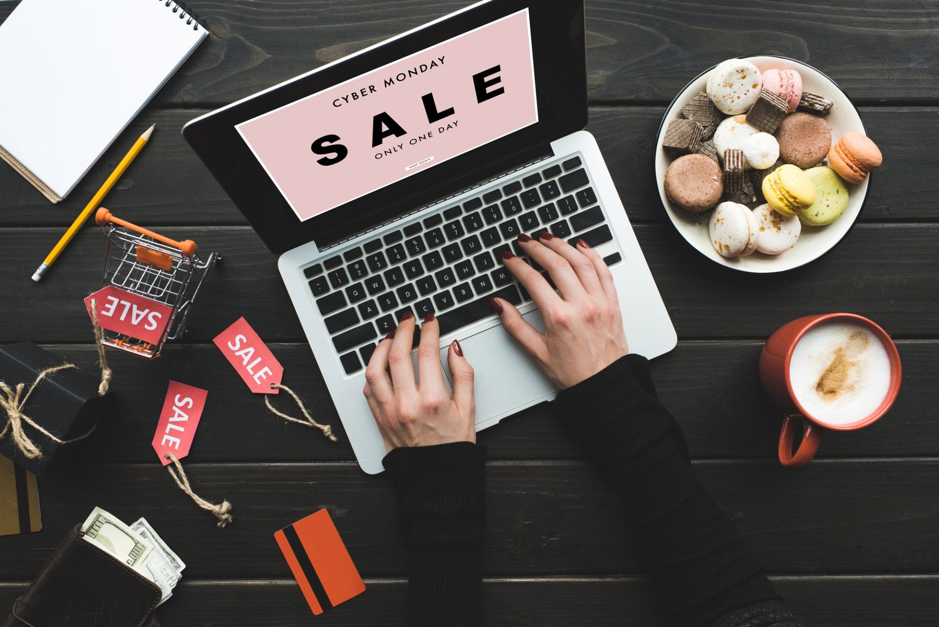 A person is typing on a laptop with the word sale on the screen