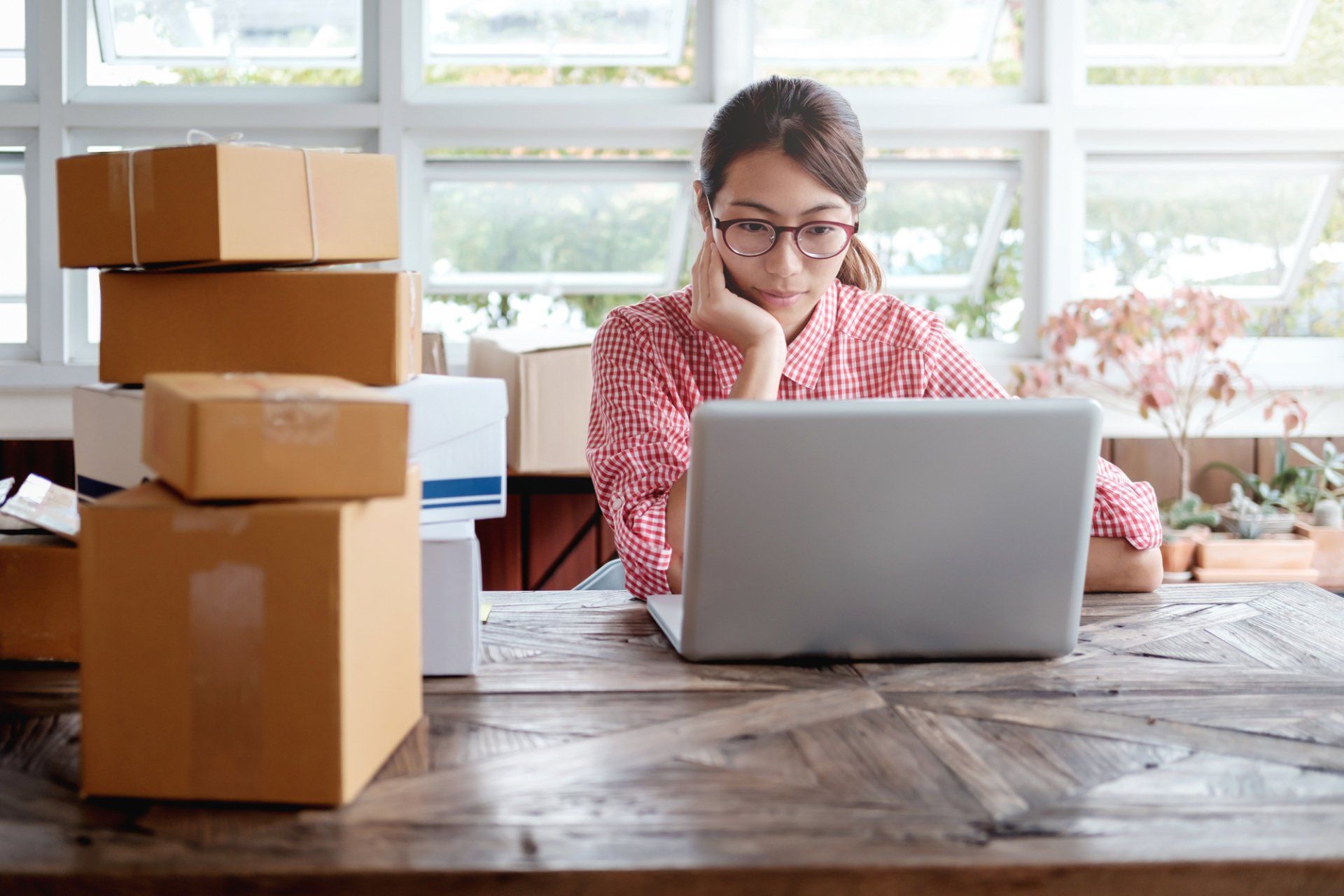 A woman is sitting at a desk using a laptop computer.