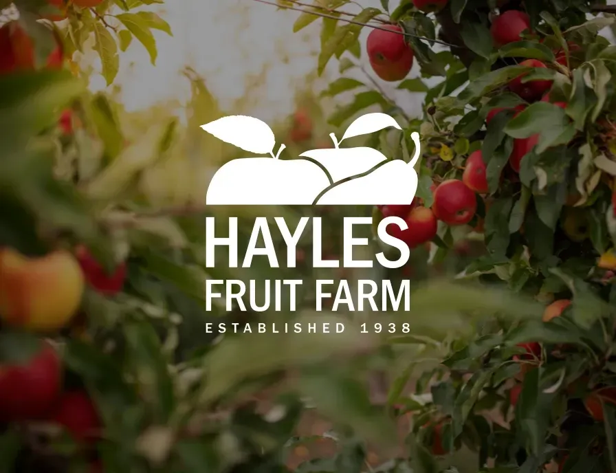 A logo for hayles fruit farm is displayed in front of an apple tree