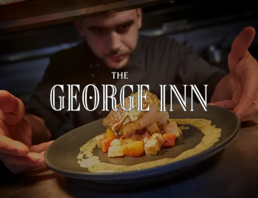 A man is preparing food at the george inn