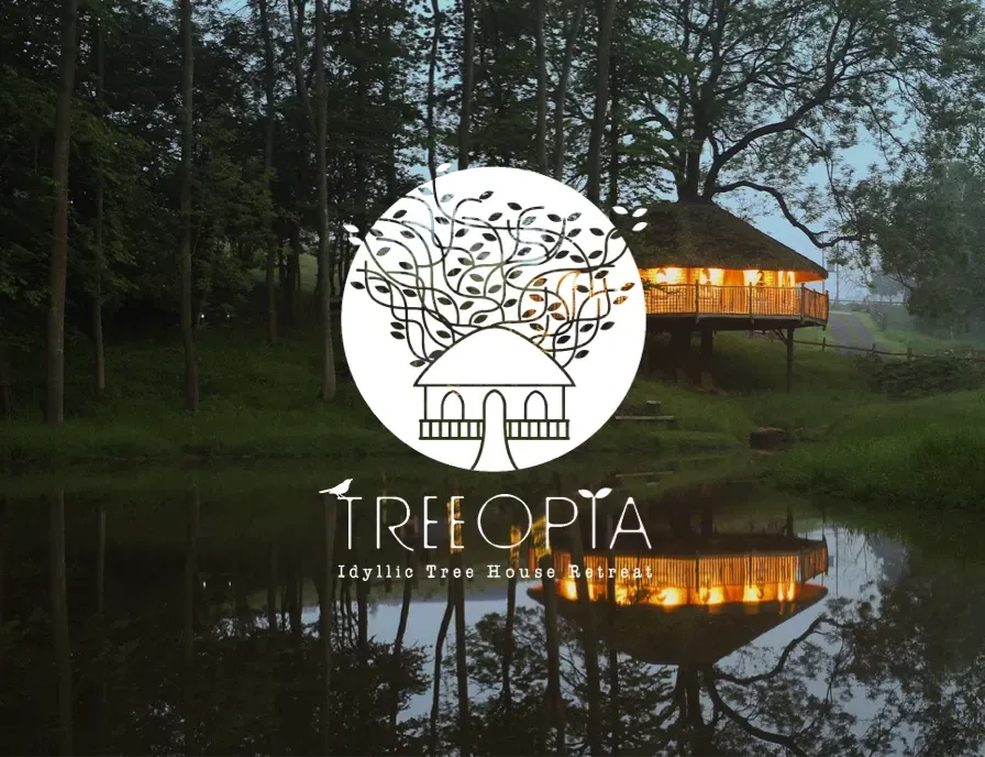A tree house in the middle of a forest with the logo for treeopia