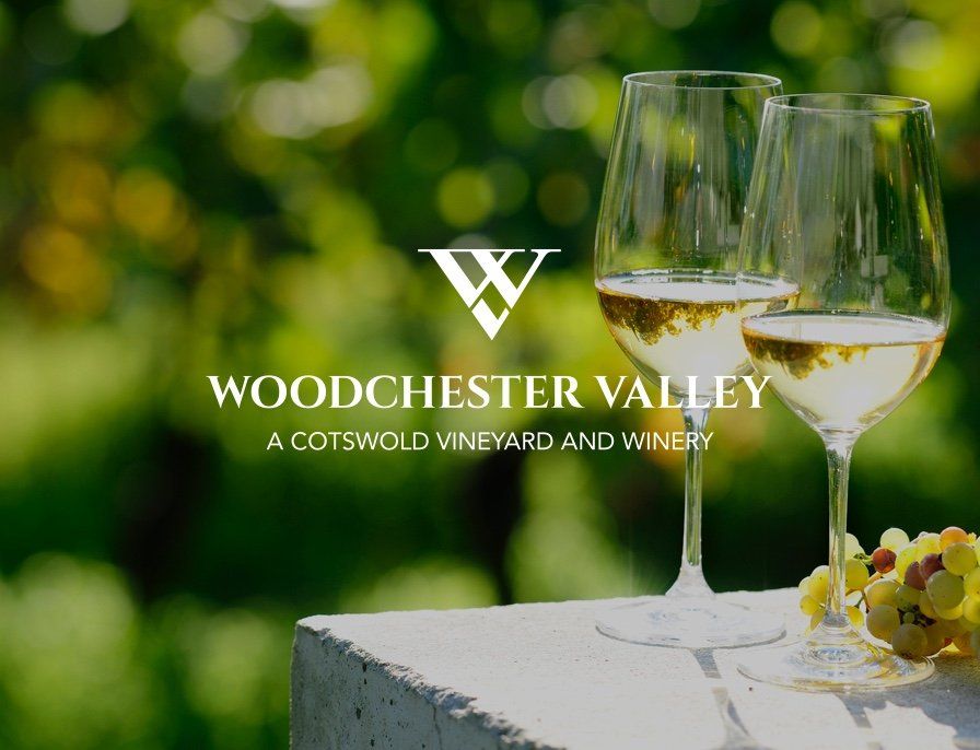 Two glasses of white wine with the words woodchester valley a cotswold vineyard and winery