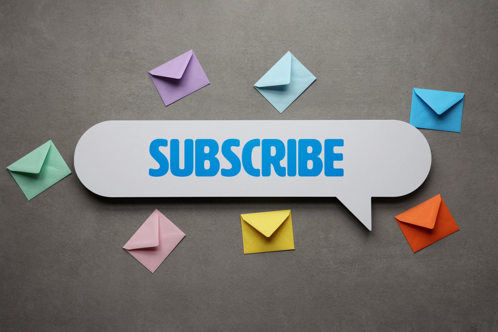 A speech bubble that says subscribe is surrounded by colorful envelopes