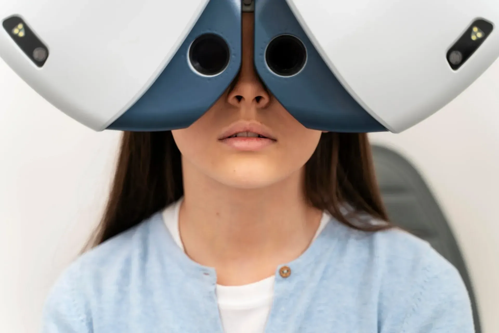A person wearing a white and dark blue vision testing device during an eye exam.