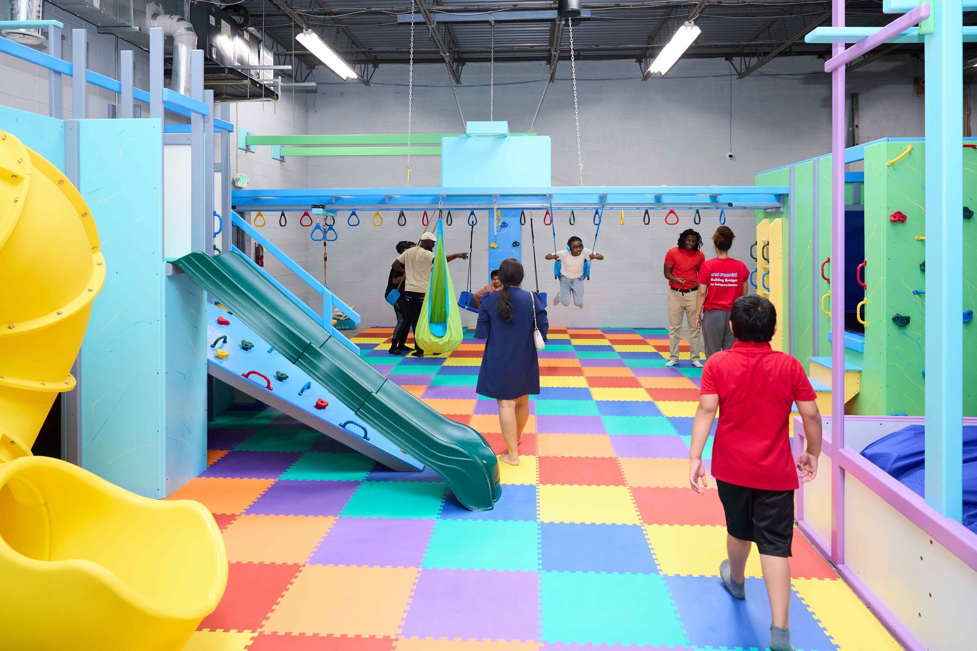 Kids playing in a colorful indoor playground with slides and climbing equipment